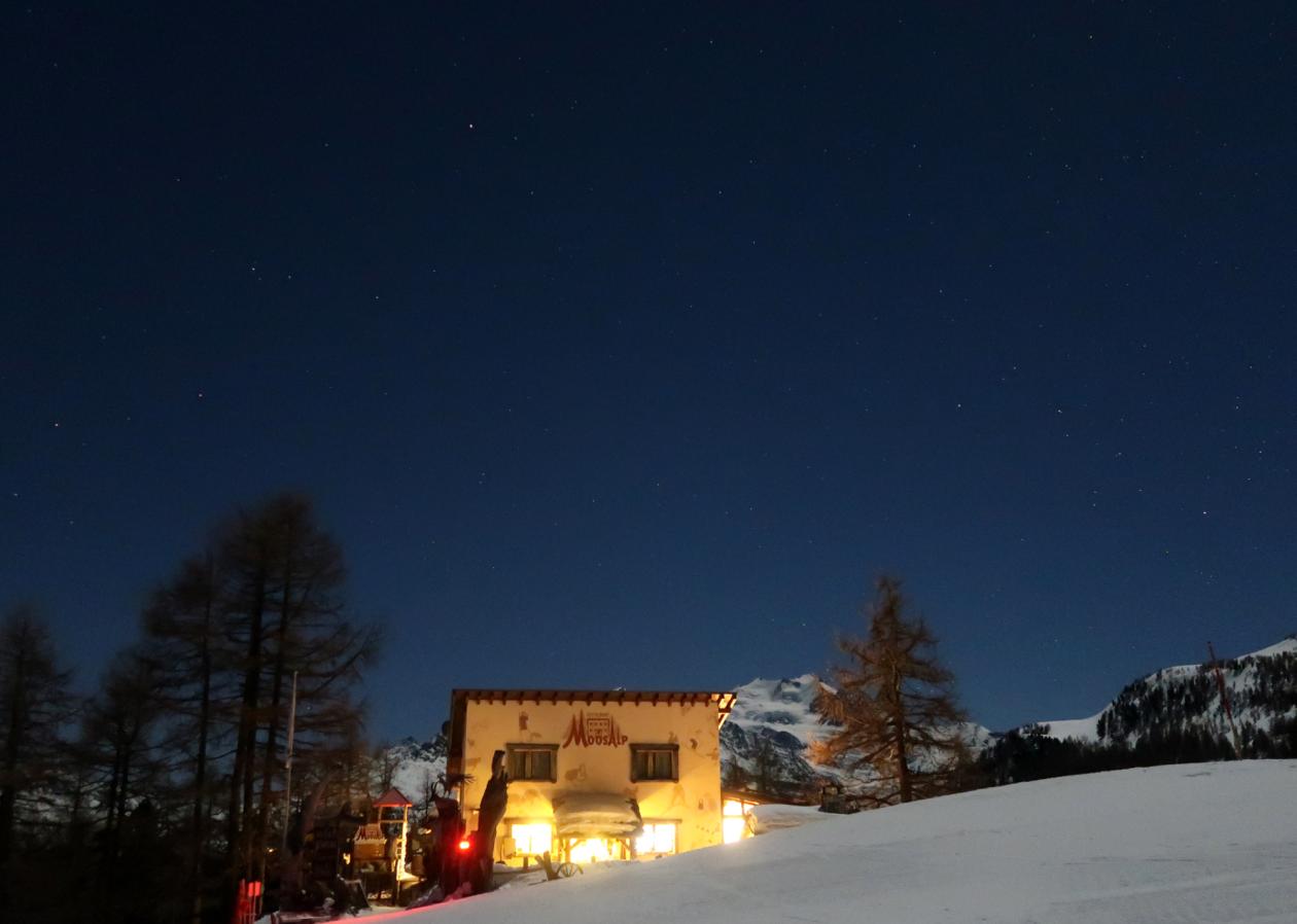 Kleines warmes Restaurant Moosalp vor der Mischabelgruppe in kühler Nacht.